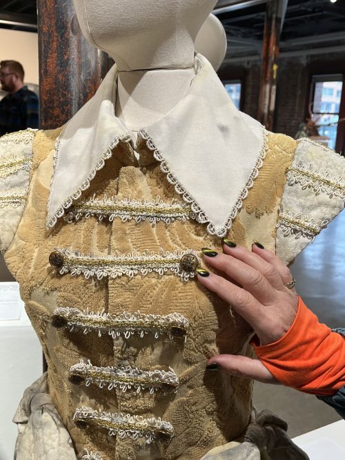 A visitor feels an embroidered doublet at Please Touch 2024