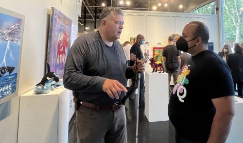 Photo of John Halliday talking with a gallery visitor